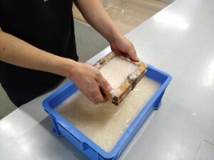 木枠と木枠の間に、簾（す）・さらし布の順にはさんで、ずれないようにしっかり持つ。

パルプをとかした水の中に木枠を垂直に入れ、溶液中では水平にする。

水からすくいあげて、静かにゆすって水をきる。