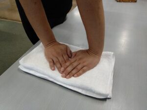 板と木枠をはずして、さらし布ごとタオルにはさむ。

タオルの上に板をおいて、体重をかけるようにしっかり押す。