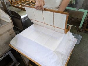 水の切れるのを待ち、水が切れたら台の上に重ねていきます。